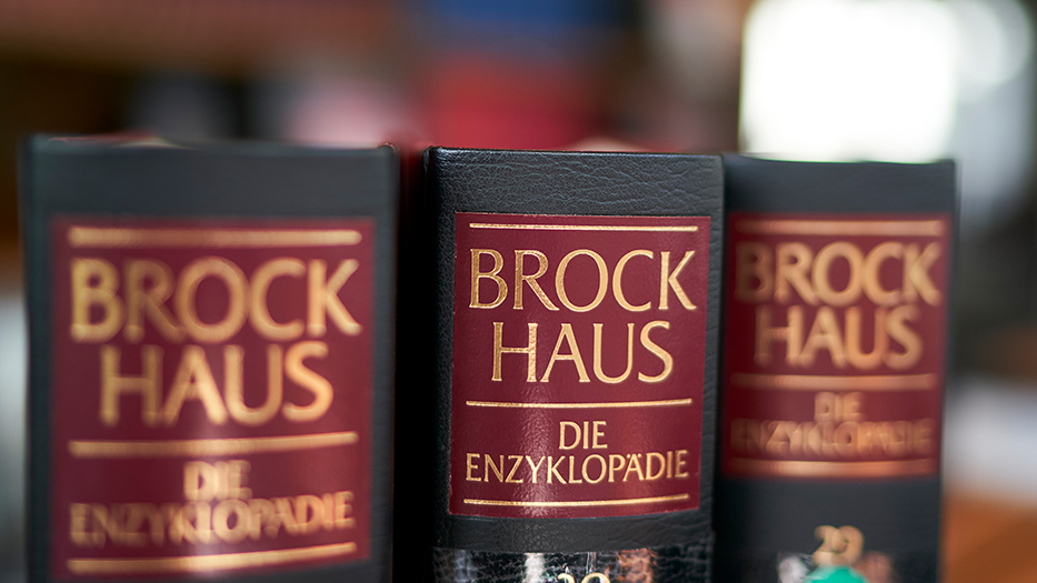 Drei Brockhaus-Bände im Bücherregal